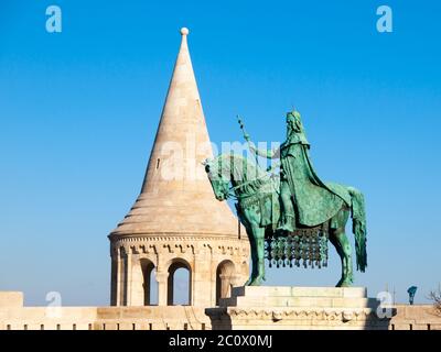 Statue montée de Saint Stephen I, alias Szent Istvan kiraly - le premier roi de Hongrie à la tour blanche typique arrondie du bastion des pêcheurs au château de Buda à Budapest, Hongrie, Europe. Photo de jour ensoleillée avec ciel bleu sur l'arrière-plan. Banque D'Images