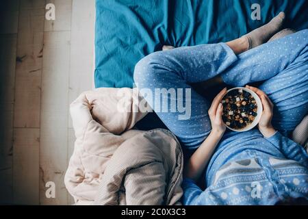 Photo de la vue supérieure d'une femme portant un pyjama avec des habitudes saines de manger des céréales Banque D'Images