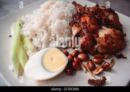 Nourriture malaisienne épicée avec poulet, riz, œuf et arachides Banque D'Images