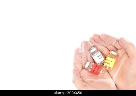 Mains en cuppées tenant plusieurs flacons de vaccin Covid-19 isolés sur fond blanc. Concept Hope, vue de dessus avec espace de copie. Banque D'Images