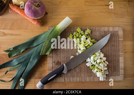 Vue de dessus d'une planche à découper, légumes d'hiver, brosse et couteau sur une table en bois Banque D'Images