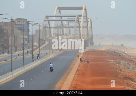 Route côtière presque vide et plage également vide dans le quartier de Guediawaye, Dakar, Sénégal Banque D'Images