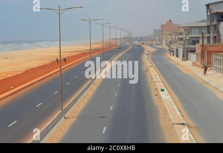 Route côtière presque vide et plage également vide dans le quartier de Guediawaye, Dakar, Sénégal Banque D'Images