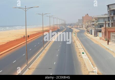 Route côtière presque vide et plage également vide dans le quartier de Guediawaye, Dakar, Sénégal Banque D'Images