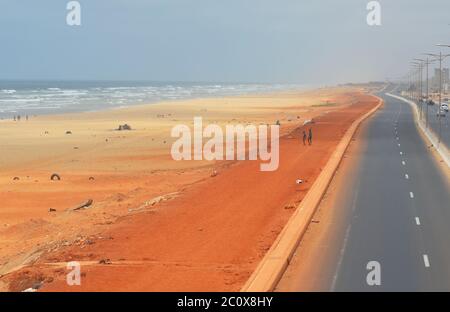 Route côtière presque vide et plage également vide dans le quartier de Guediawaye, Dakar, Sénégal Banque D'Images