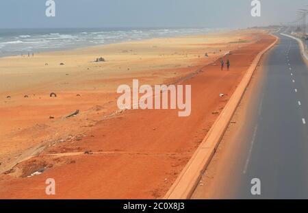 Route côtière presque vide et plage également vide dans le quartier de Guediawaye, Dakar, Sénégal Banque D'Images