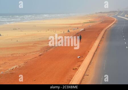 Route côtière presque vide et plage également vide dans le quartier de Guediawaye, Dakar, Sénégal Banque D'Images