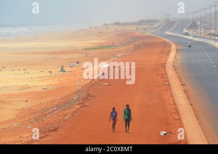 Route côtière presque vide et plage également vide dans le quartier de Guediawaye, Dakar, Sénégal Banque D'Images