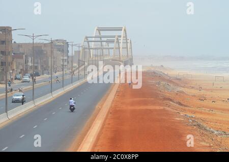 Route côtière presque vide et plage également vide dans le quartier de Guediawaye, Dakar, Sénégal Banque D'Images