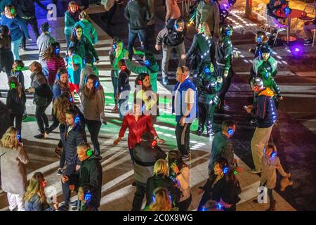 Avec des écouteurs sans fil, les danseurs ont trois choix de musique, chacun avec son propre disc-jockey, lors d'un festival de nuit 'Silent Disco' en plein air à Costa Me Banque D'Images