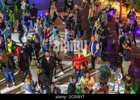 Avec des écouteurs sans fil, les danseurs ont trois choix de musique, chacun avec son propre disc-jockey, lors d'un festival de nuit 'Silent Disco' en plein air à Costa Me Banque D'Images