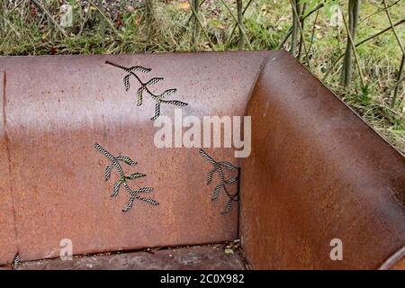 Siège en métal rouillé avec motif feuilles et bords incurvés Banque D'Images