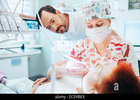 Minsk, Bélarus - 11 juin 2020 : un jeune dentiste traite une dent de patient sous la supervision d'un médecin expérimenté Banque D'Images