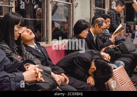 Passagers dormant dans un train de nuit à Hiroshima, Japon Banque D'Images