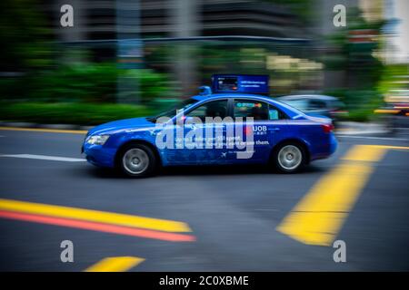 Taxi flou en mouvement dans le centre-ville. Centre de Singapour Banque D'Images