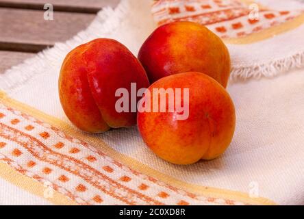 Les abricots sont sur une serviette brodée sur une table en bois Banque D'Images