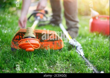 Jardinier préparant le coupe-herbe sur la pelouse en plein air. Photo de haute qualité Banque D'Images