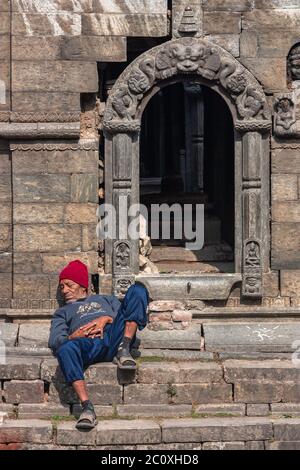 homme sans abri dormant près de l'entrée du temple Banque D'Images