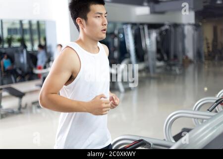 jeune homme charmant s'entraîner dans la salle de gym moderne Banque D'Images