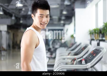 jeune homme charmant s'entraîner dans la salle de gym moderne Banque D'Images