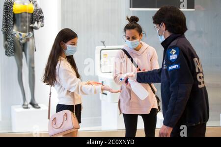 Brantford, Canada. 12 juin 2020. Un agent de sécurité nettoie les mains d'un client à l'entrée du centre commercial Lynden Park à Brantford, Ontario, Canada, le 12 juin 2020. La province de l'Ontario a permis à la plupart des régions situées à l'extérieur des régions de Toronto et de Hamilton de rouvrir vendredi d'autres entreprises durant l'éclosion de la COVID-19, y compris les terrasses de restaurants, les salons de coiffure et les centres commerciaux. Credit: Zou Zheng/Xinhua/Alamy Live News Banque D'Images