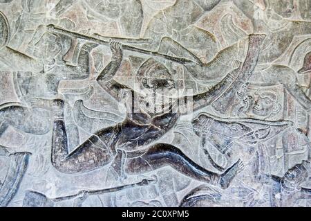 Ancienne sculpture de secours du bas d'un soldat qui lance une lance pendant la bataille. Mur intérieur du temple d'Angkor Wat, Siem Reap, Cambodge. Banque D'Images