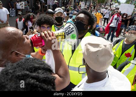 Newark, New Jersey, États-Unis. 12 juin 2020. Un manifestant de Newark, à gauche, avec une corne de taureau, affronte un manifestant de la Newark Water Coalition pendant une marche et se rallie à Newark, dans le New Jersey. Le protestataire de Newark et d'autres ont empêché la coalition de poursuivre sa route de l'université secondaire à la cinquième Cité de Newark. Crédit : Brian Branch Price/ZUMA Wire/Alay Live News Banque D'Images