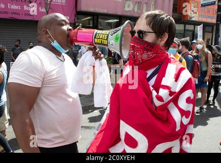 Newark, New Jersey, États-Unis. 12 juin 2020. Un manifestant de Newark, à gauche, avec une corne de taureau, affronte un manifestant de la Newark Water Coalition pendant une marche et un rallye à Newark. Le protestataire de Newark et d'autres ont empêché la marche de la coalition de se poursuivre sur leur route de l'école secondaire de l'université à la cinquième Cité de Newark. Crédit : Brian Branch Price/ZUMA Wire/Alay Live News Banque D'Images