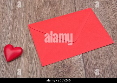 Enveloppe rouge et le cœur sur un fond de bois Banque D'Images