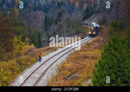 Vue aérienne d'un train sur une voie ferrée avec un photographe prenant des photos. Banque D'Images