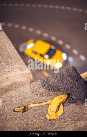 Taxi jaune passant coin sur l'arrière-plan flou avec peau de banane en face Banque D'Images