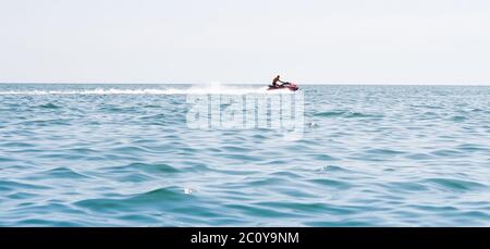 Jeune homme qui navigue sur un jet ski sur la mer Banque D'Images