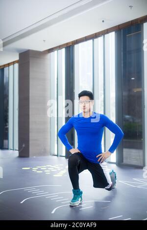 Young Asian man doing yoga Yoga au sport moderne Banque D'Images