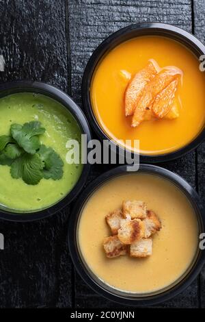 soupe à la crème de pois verts, soupe à la crème de lentilles rouges et sans viande, soupe de légumes dans trois boîtes alimentaires Banque D'Images