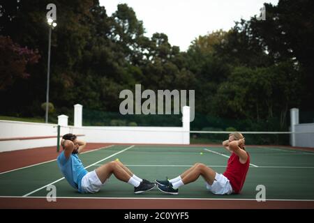 Les hommes de race blanche s'entraîner sur un court de tennis Banque D'Images