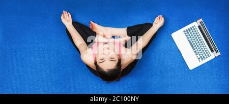 Bannière asiatique femme pratiquant le yoga à la maison avec un ordinateur portable quand Covid19 épidémie, exercice sain ou de méditation, entraînement à la maison, pandémie de coronavirus Banque D'Images