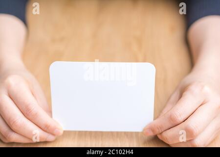 Woman's hand holding white papier vierge Banque D'Images