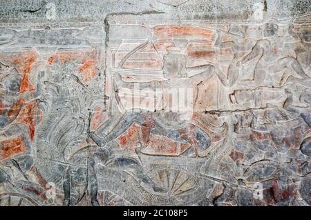 Ancien bas Khmer relief sculpture montrant le dieu hindou Shiva tirant une flèche d'un char tiré par un Naga - un Dieu de serpent à plusieurs têtes. Mur d'Angkor Banque D'Images