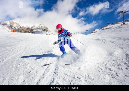 Action mouvement à grande vitesse de la fille ski alpin dans les montagnes Banque D'Images