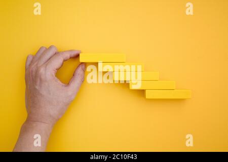 escaliers à la main avec des blocs de domino jaunes Banque D'Images