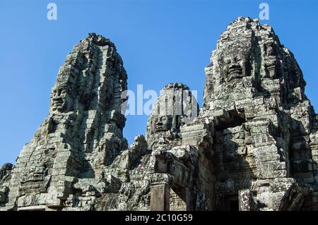 Vue sur les tours sculptées avec des visages de Bodhista. Partie de l'ancien temple khmer Bayon, Angkor Thom, Siem Reap, Cambodge. Banque D'Images