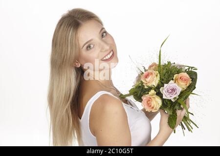 Jeune femme blonde portant un bouquet de fleurs (roses) Banque D'Images