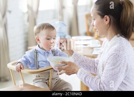 Belle jeune femme nourrit son fils bébé Banque D'Images