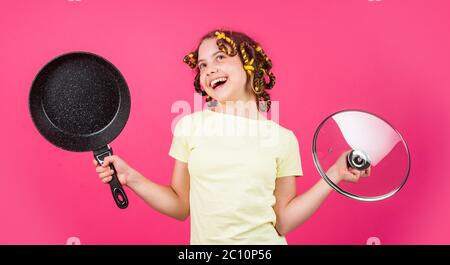 juste inspiré. petite femme tient la poêle. cuisine dans la cuisine. concept de ménage. cuisine pour enfants à la maison. enfance heureuse. jeune enfant joyeux avec des pillards. ménage de l'enfance. Banque D'Images