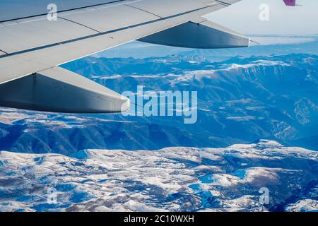 Vue sur les impressionnantes montagnes des Balkans en avion. Vue panoramique aérienne sous l'aile d'un avion, hautes montagnes couvertes de neige. Banque D'Images