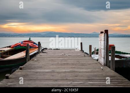 Jetée et petit bateau en bois au crépuscule dans l'Albufera à Valence, un lagon d'eau douce et un estuaire dans l'est de l'Espagne. Exposition longue. Banque D'Images