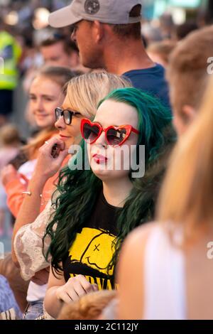Une jeune femme flamboyante aux cheveux verts fait partie de la foule de personnes qui assistent aux célébrations de la rue du 4th juillet Parade et aux célébrations du jour de l'indépendance à Killarney, comté de Kerry, Irlande Banque D'Images