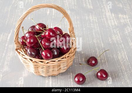 Panier en osier rempli de cerises fraîches Banque D'Images