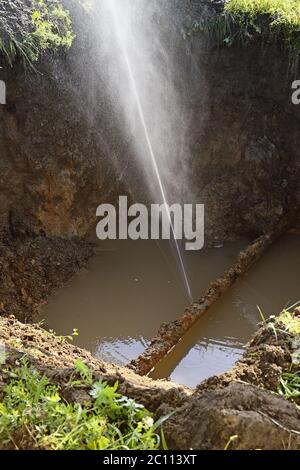 Le jet d'eau sous forme de fuite dans le tuyau métallique endommagé sur le site de production Banque D'Images