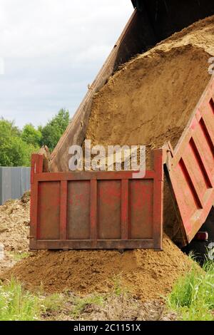 Les déchargements de camions de sable pour le remplissage des tranchées avec le pipeline après l'accident. Banque D'Images